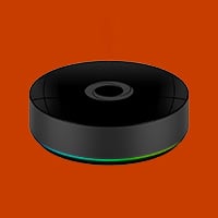 Svart rund smarta hem-controller med grön LED-ring mot röd bakgrund.