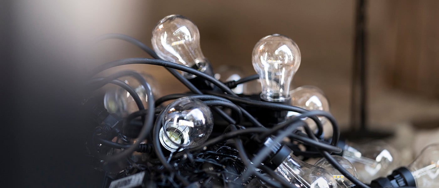 Närbild på en bunt svarta ljusslingor med genomskinliga LED-glödlampor i retrostil.