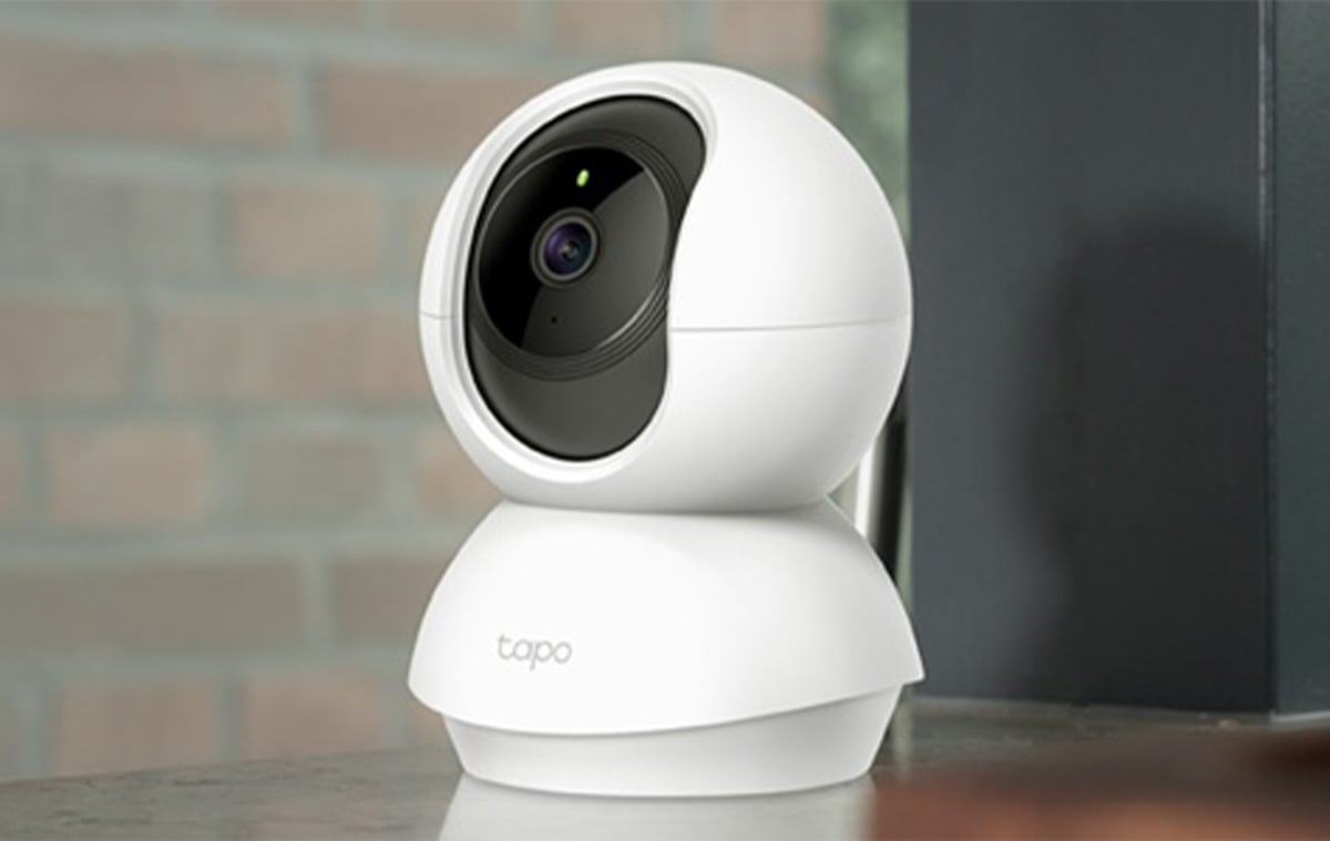 Vit bakgrund med en svart och vit övervakningskamera.