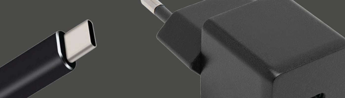 Svart USB-laddare och flätad USB-C-kabel mot mörkgrå bakgrund