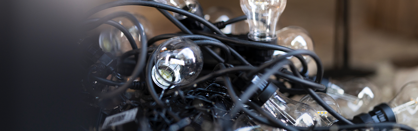 Gamle lyspærer og ledninger i en haug – elektronikkavfall klart for resirkulering.
