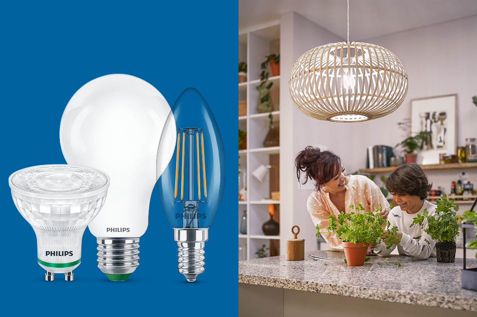 Tre Philips LED-lampor i olika modeller mot blå bakgrund, bredvid en bild på en kvinna och ett barn i ett kök upplyst av en taklampa i rotting.