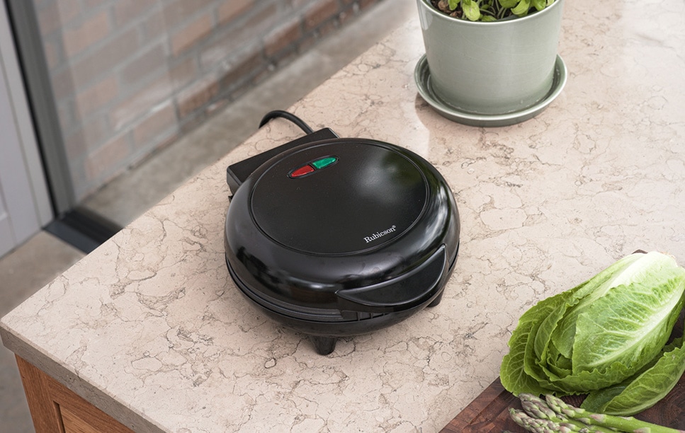 Svart omelettjärn från Rubicson står på en köksbänk bredvid sallad och sparris.