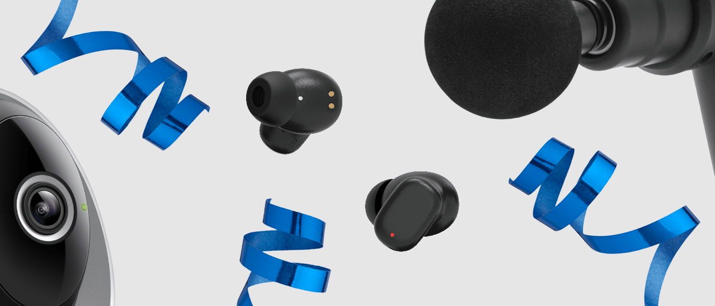 Svart massagepistol, airfryer med digital skärm och trådlösa hörlurar i etui, omgivna av blå presentsnören.