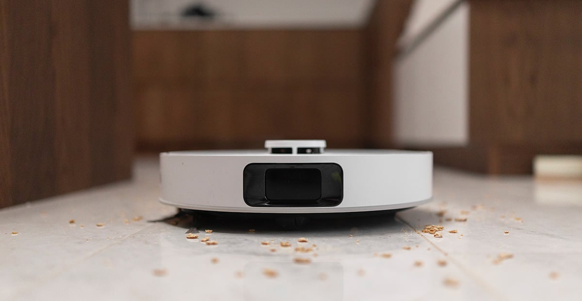 Dreame robotdammsugare i vitt på grått matta i vardagsrum.