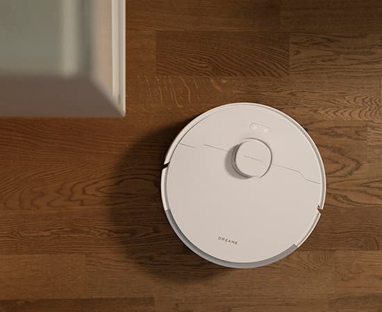 Vit robotdammsugare på trägolv i hemmiljö