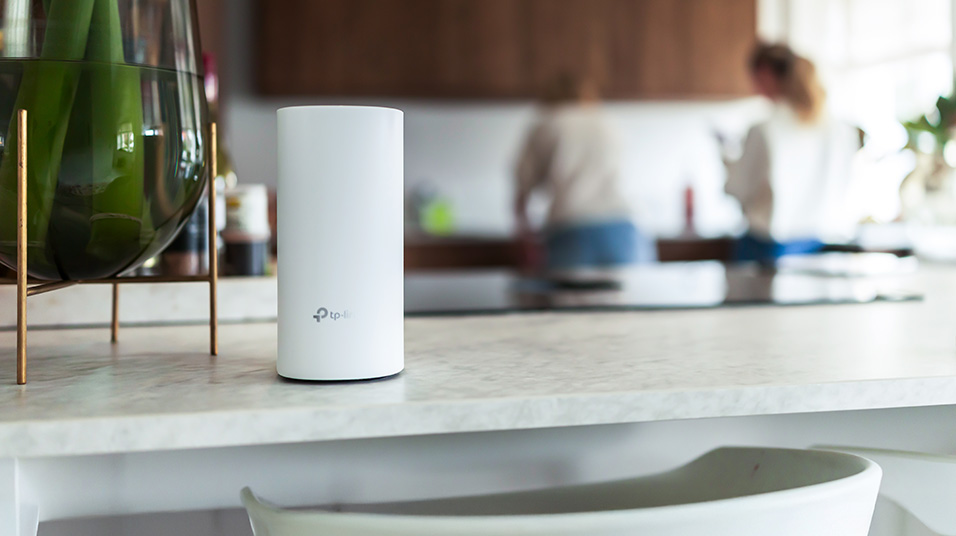 Modernt kök med en mesh wifi-router placerad på bordet bland hemdekoration, illustrerar stabil trådlös täckning i hemmet